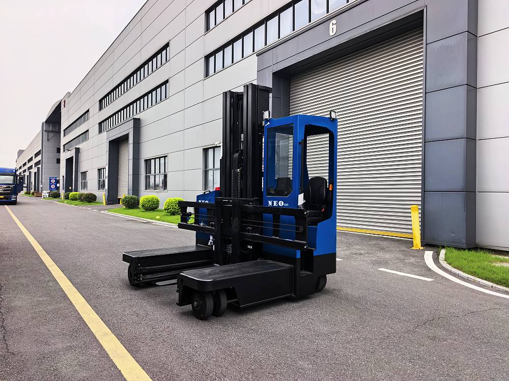 NEO FORKLIFT electric multi-directional forklift outside a warehouse loading dock NEO FORKLIFT electric multi-directional forklift outside a warehouse loading dock